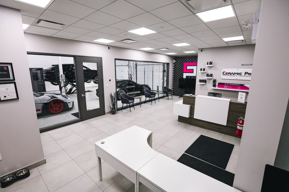 Spacious and modern car salon with luxury cars in a pristine interior setting.